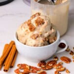 Low carb cinnamon pecan crunch ice cream scoops in a bowl and a ninja creami pint next to the bowl.
