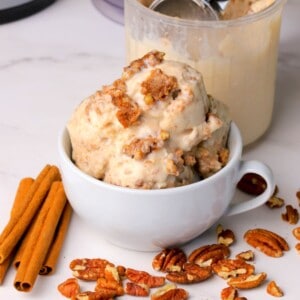 Low carb cinnamon pecan crunch ice cream scoops in a bowl and a ninja creami pint next to the bowl.