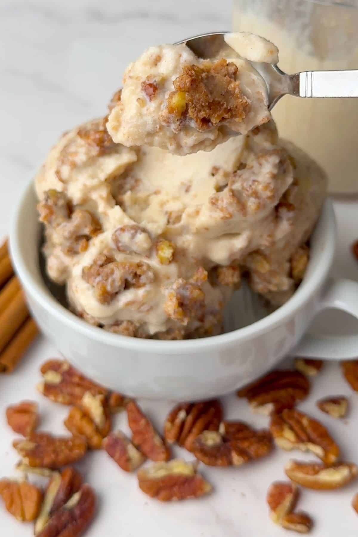 Spoon digging into the low carb cinnamon pecan crunch ice cream scoops in a bowl.