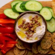 Low carb olive cottage cheese dip in a bowl surrounded by an assortment of dipping options.