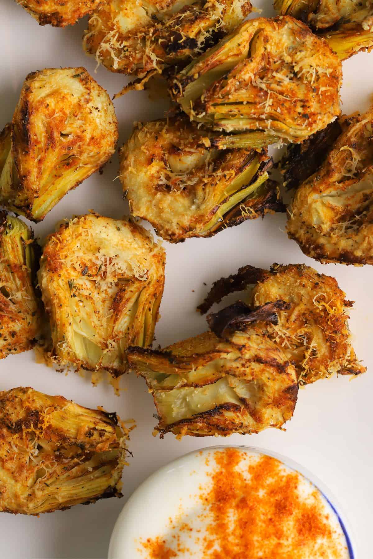 Low carb air fryer artichokes on a platter with a dip.