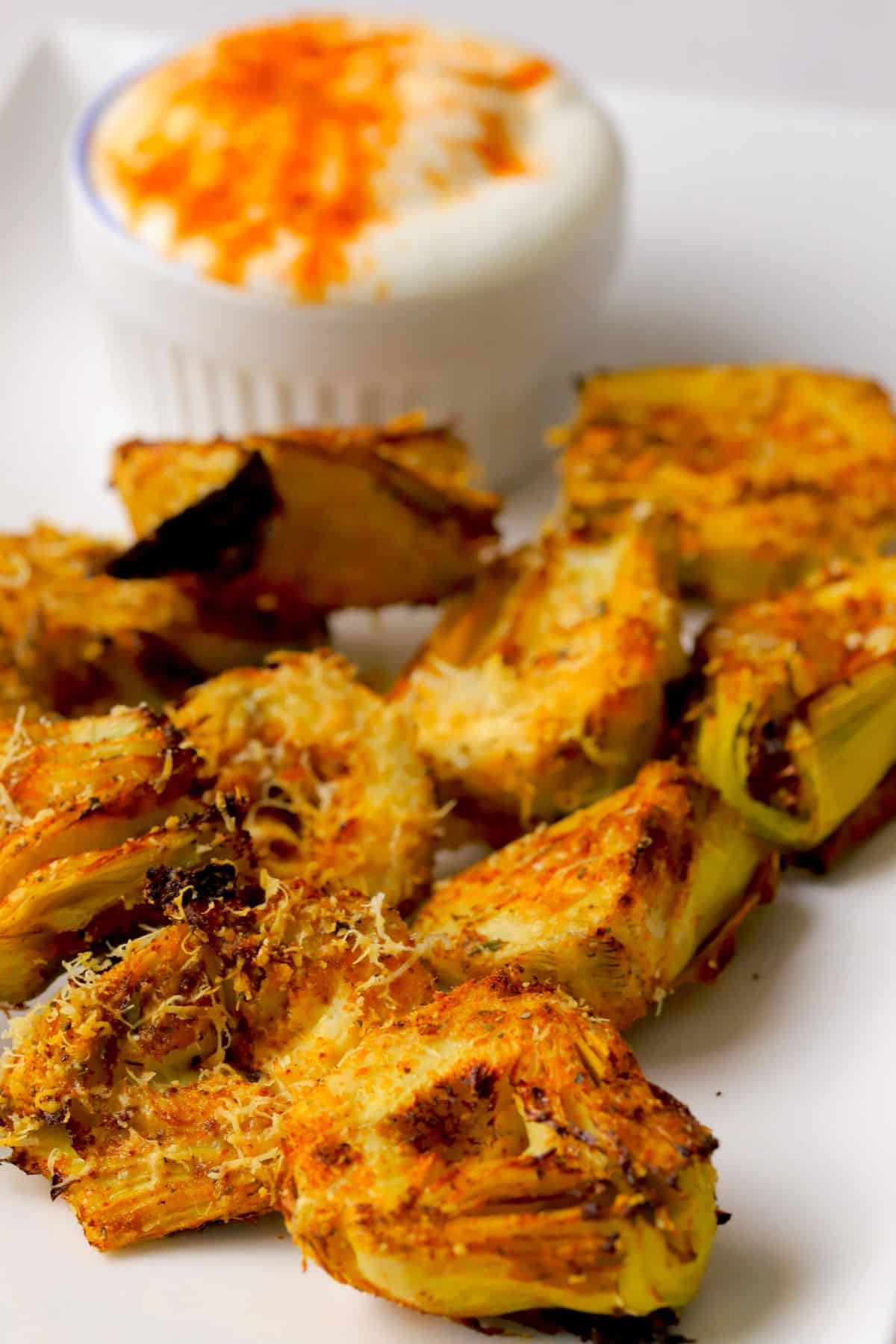 Low carb air fryer artichokes on a platter with a dip.
