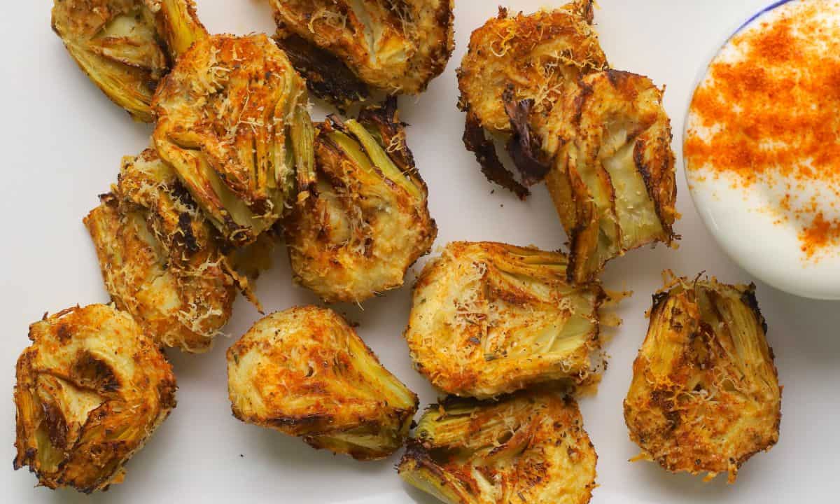 Low carb air fryer artichokes on a platter with a dip.