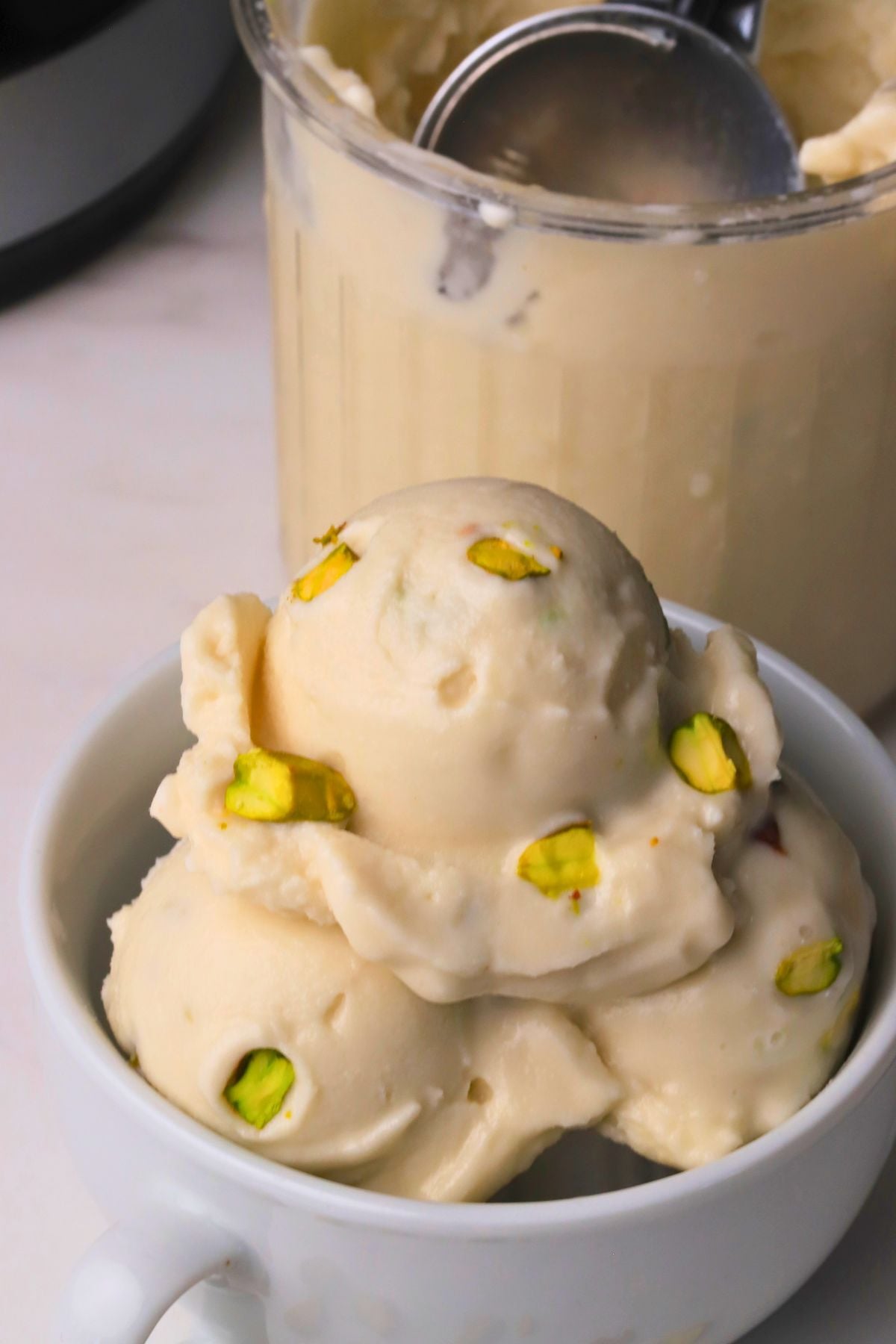 Low carb pistachio almond ice cream in a white bowl.