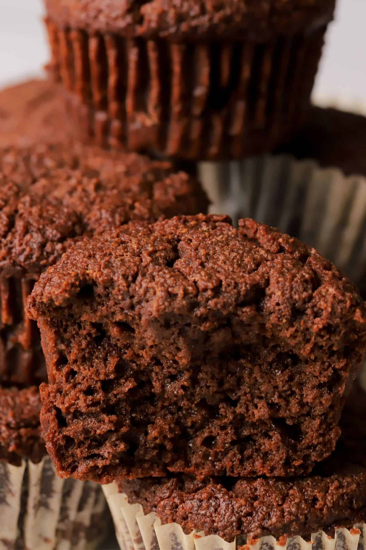 Close up of a low carb double chocolate muffin stacked on top of other muffins.