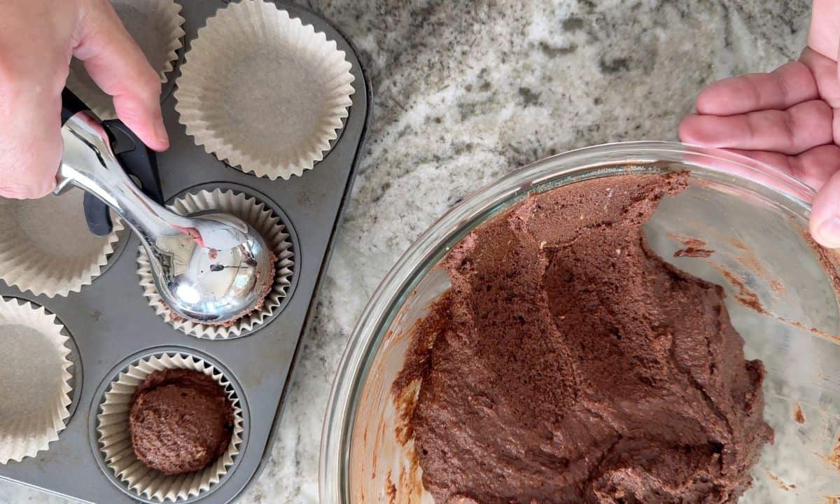 Scooping the muffin batter into the muffin liners.