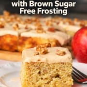 A square of low carb apple spice cake on a plate next to an apple.