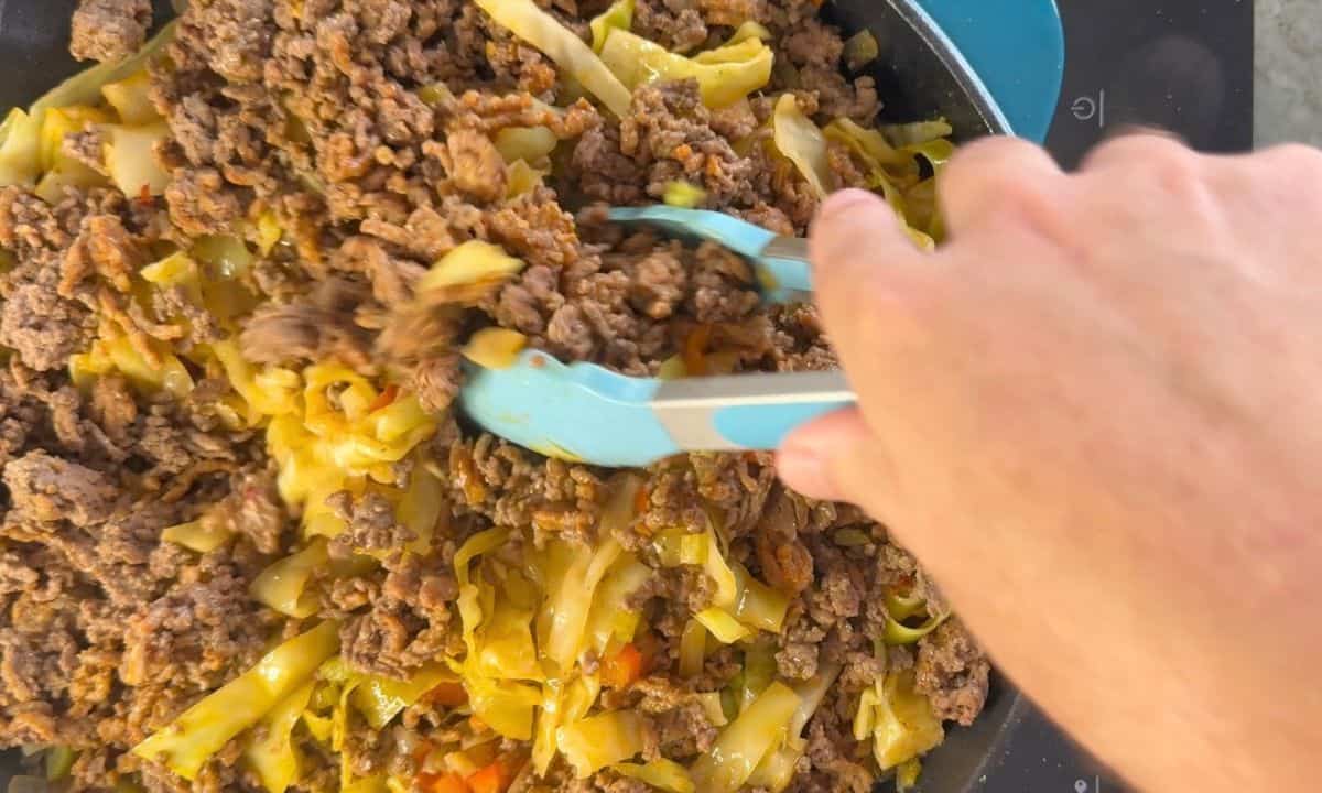 Mixing in the ground meat with the cabbage mixture.