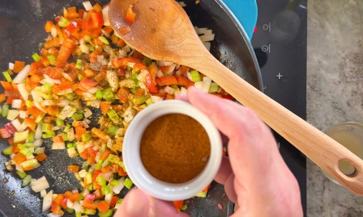 Adding the spices to the mixed vegetables.