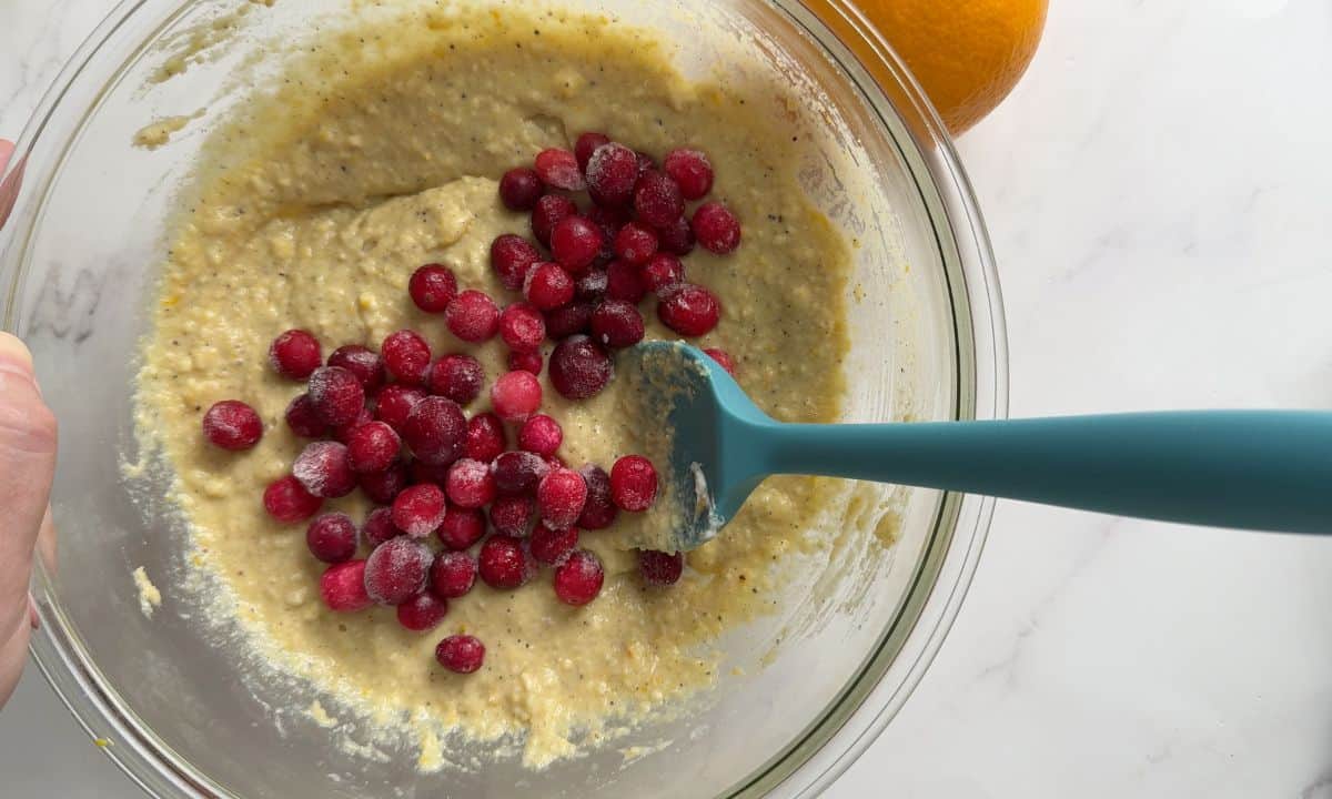 Adding frozer cranberries to the batter.