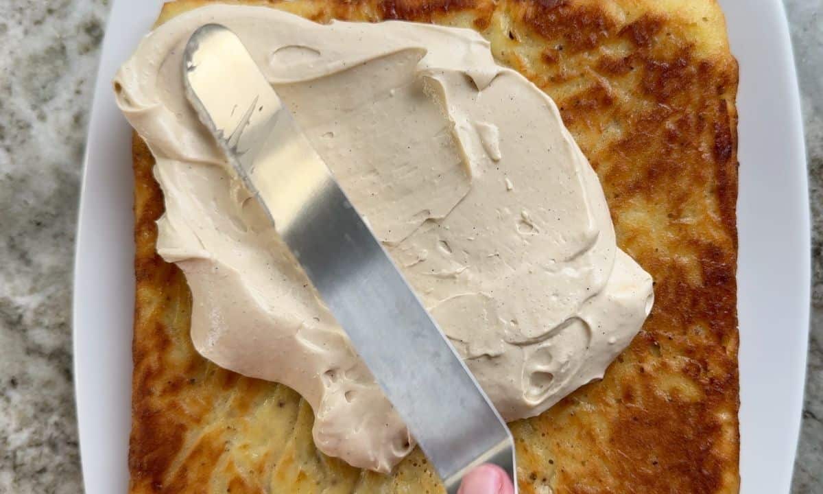 Spreading the frosting on to the cake.