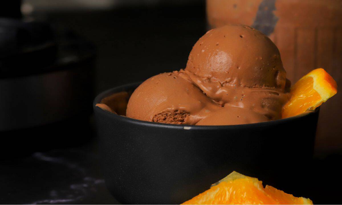 Scoops of low carb chocolate orange ninja creami ice cream in a bowl with orange segments.