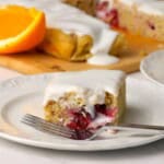 Closeup of a square of the low carb cranberry orange spice cake on a plate with a fork.