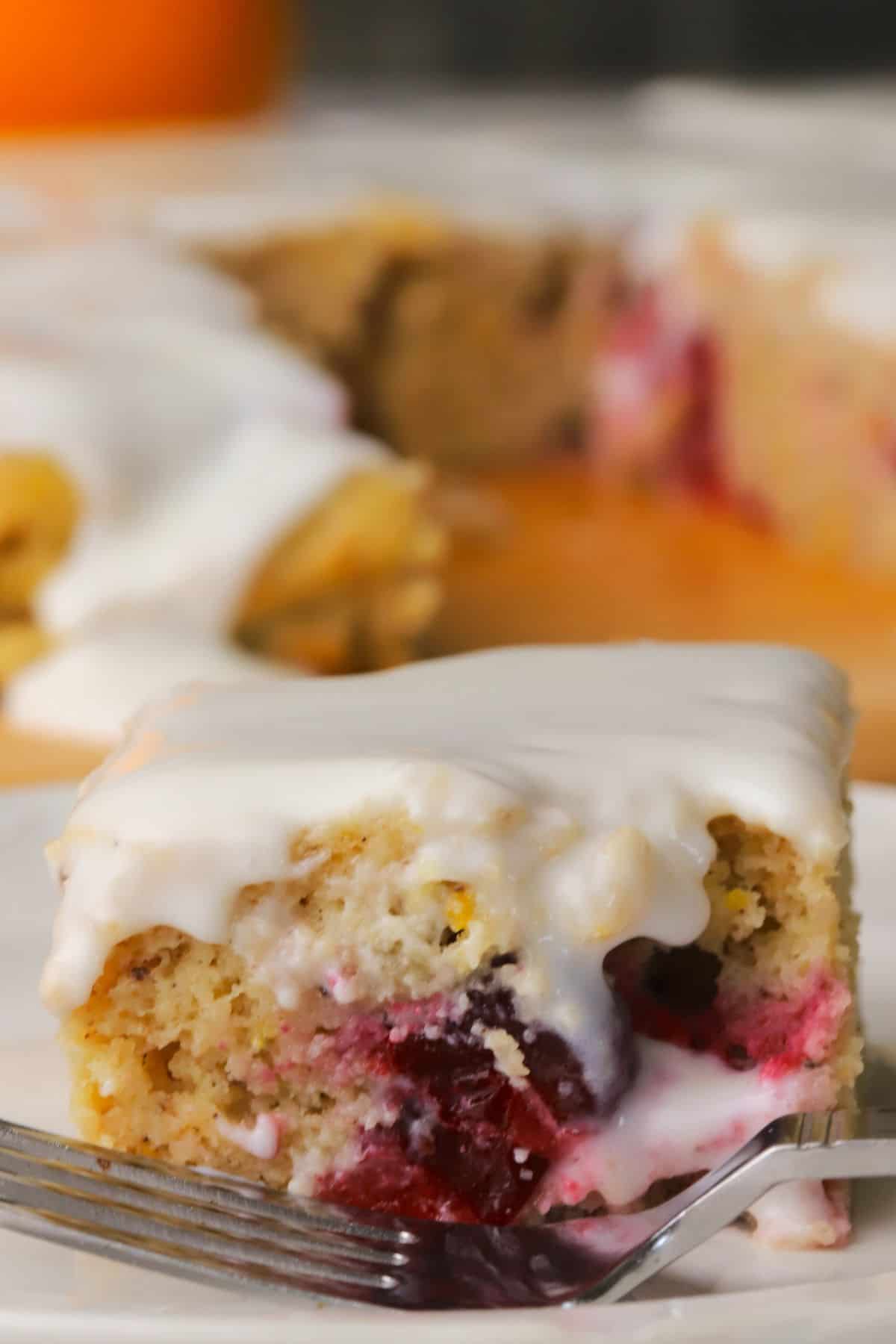 Closeup of a square of the low carb cranberry orange spice cake on a plate with a fork.