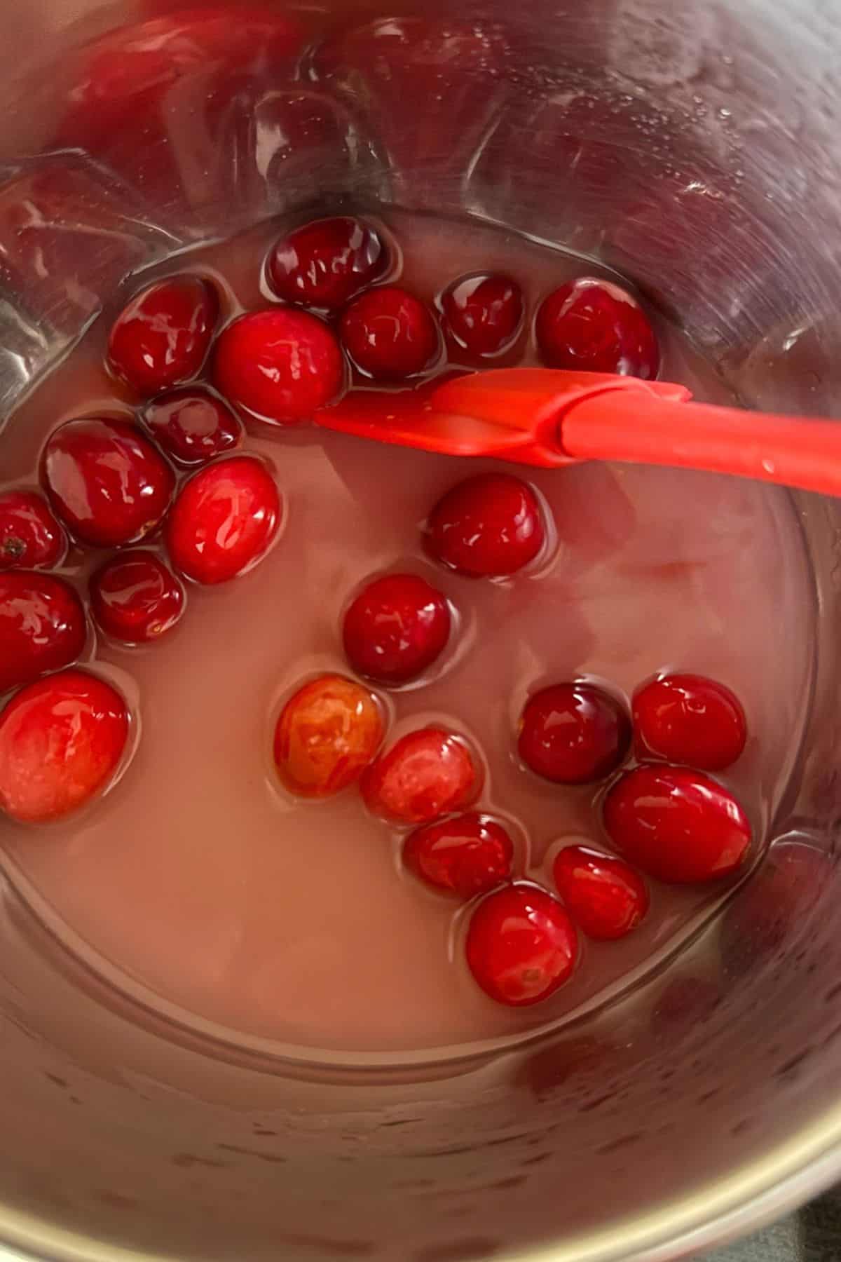 Cranberries simmering in a pot.